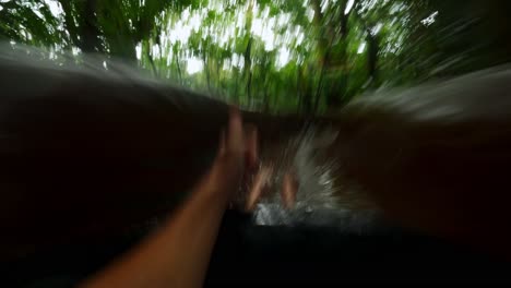 Toma-Pov-De-Un-Turista-Deslizándose-En-Un-Tobogán-De-Agua-En-La-Jungla-En-La-Selva-Tropical-Costarricense