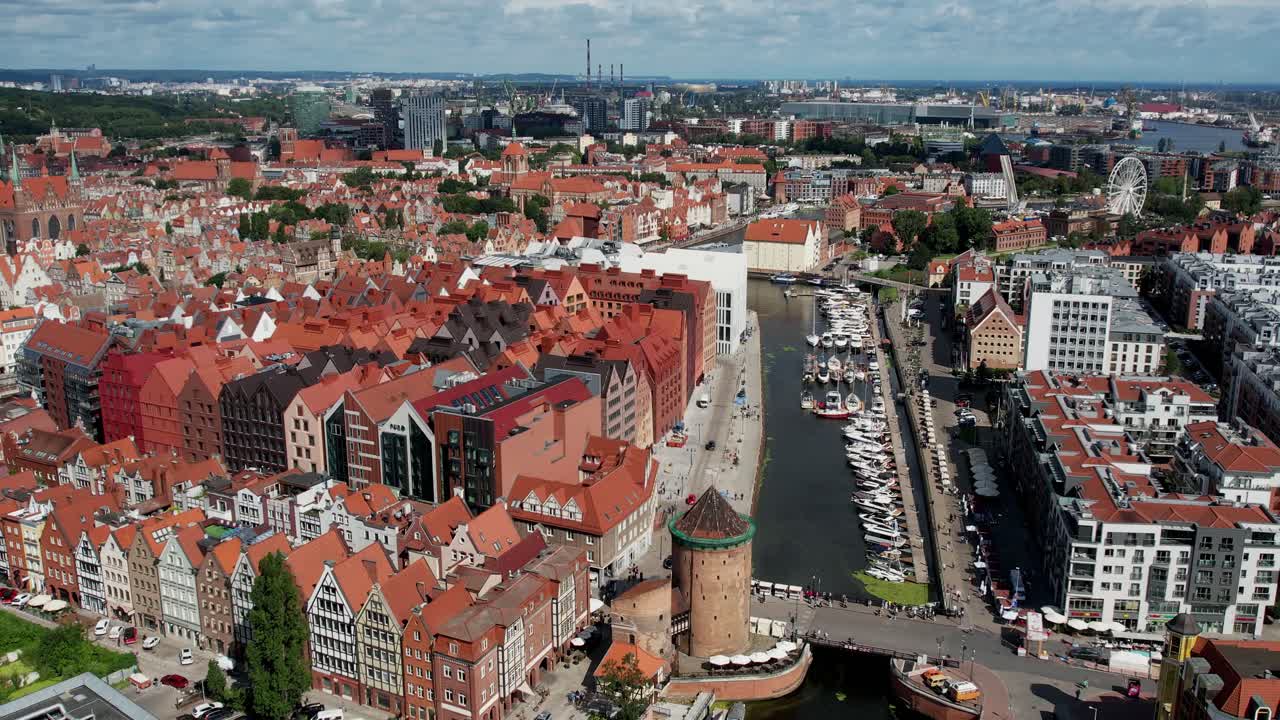 Dron letí nad starým městem v Gdaňsku a odhaluje řeku Motlawu, přístav a památky