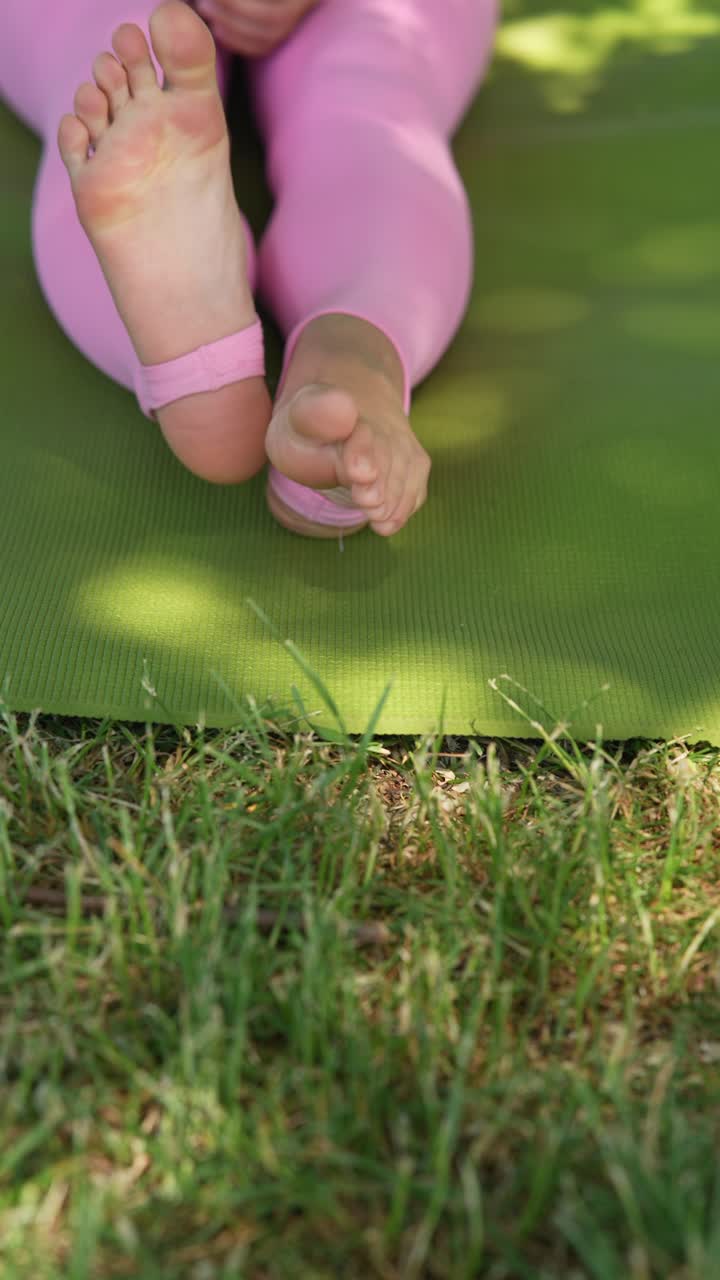 Woman practicing yoga outdoors on a mat