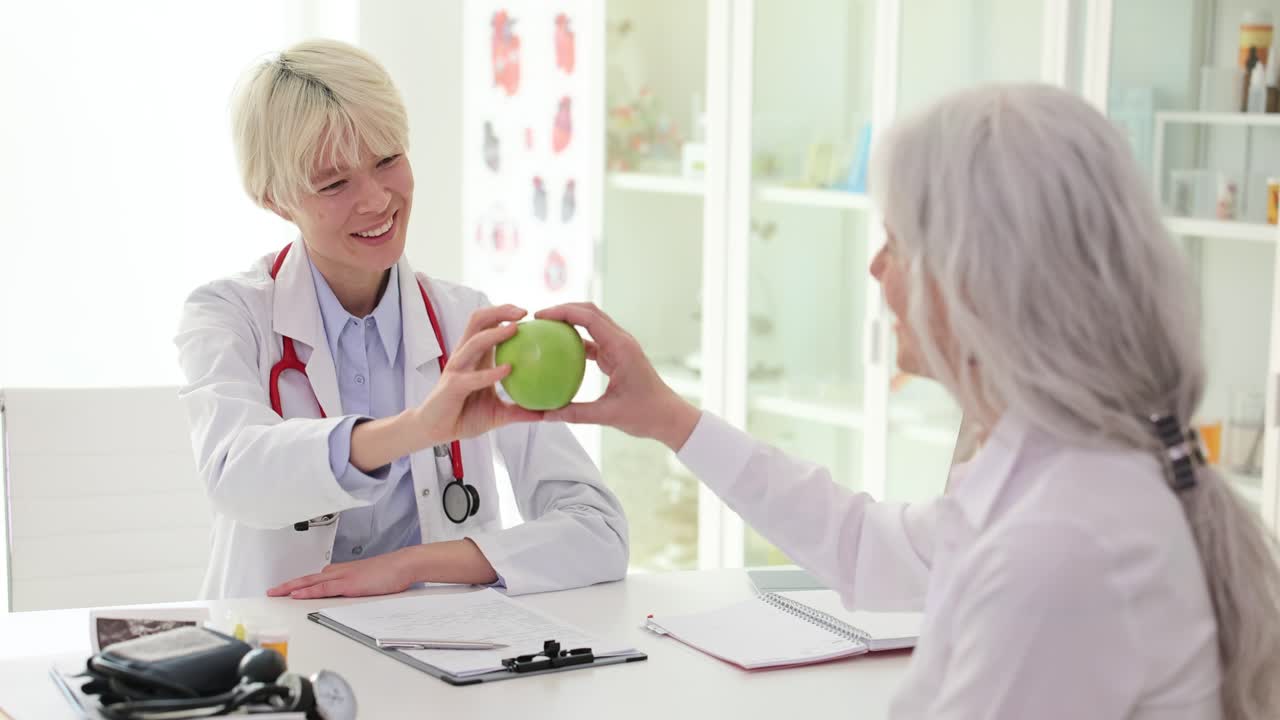 Doctor offering an apple to a patient