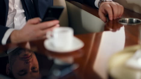 man hands using cellphone on business trip. wealthy businessman swiping phone