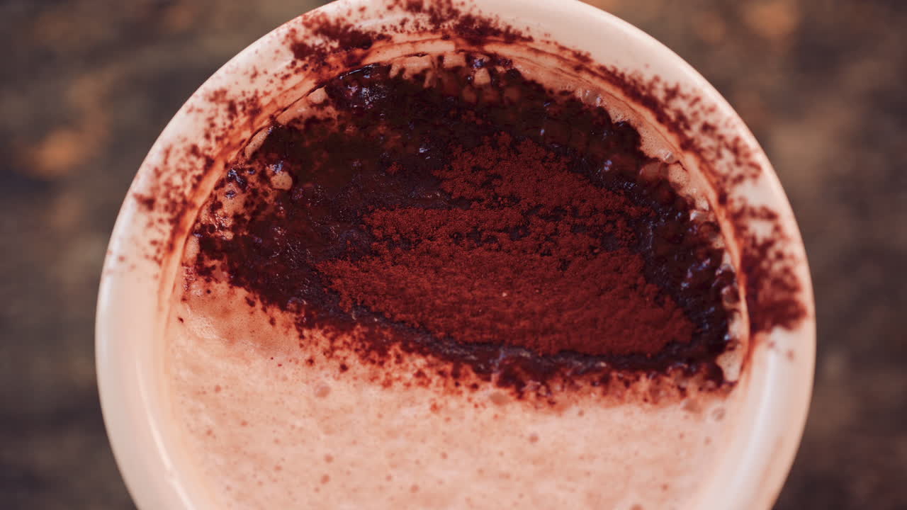 Close up of a rich hot chocolate or coffee surface sprinkled with cocoa powder