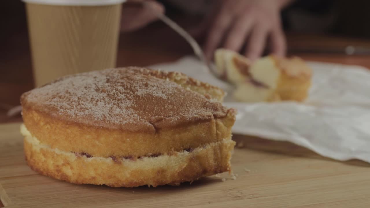 Eating Victoria sponge cake with hot drink medium shot