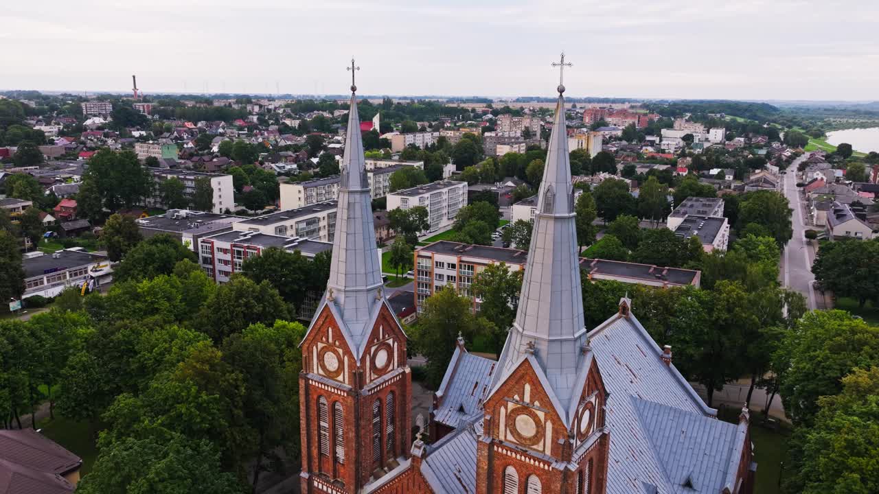 Historic red brick church towers blend with Soviet style apartments in Jurbarkas