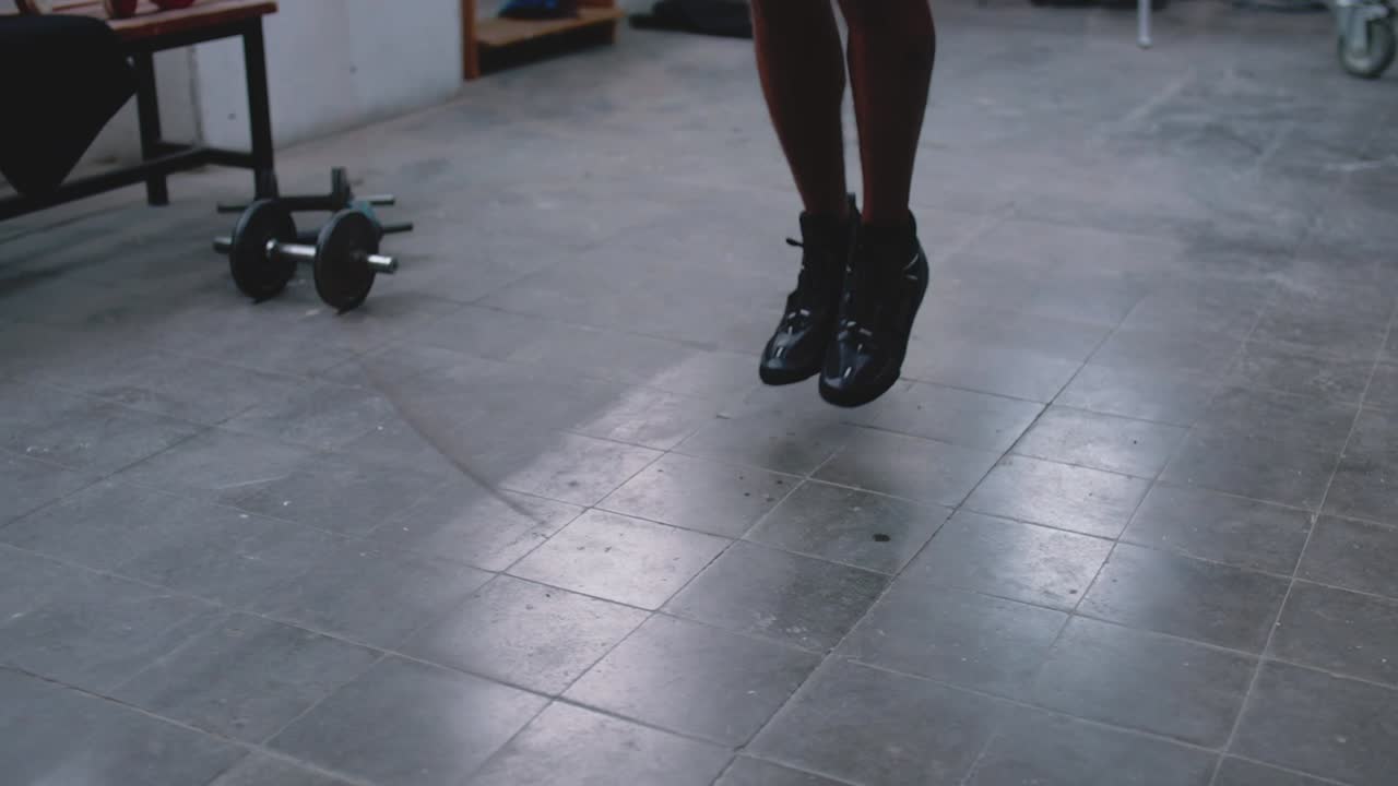 Cropped view of boxer jumping on skipping rope.