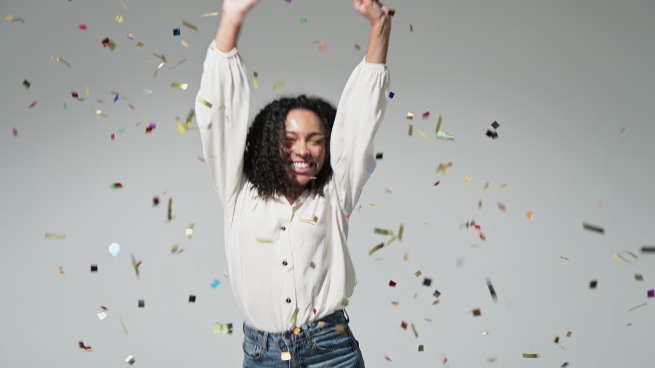 Joyful excited woman at celebration party with confetti falling everywhere