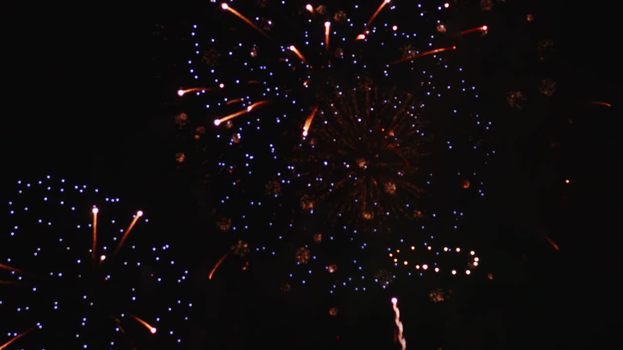 Real fireworks exploding celebration frame fill and loop seamlessly abstract blur bokeh lights in the night sky with the glowing fireworks show festival