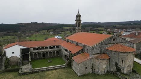 un dron se eleva sobre el monasterio de santa maría de xunqueira para revelar los campos agrícolas de ourense