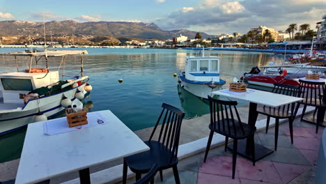 romantic dinner table restaurant next to marina port, boats moored greece