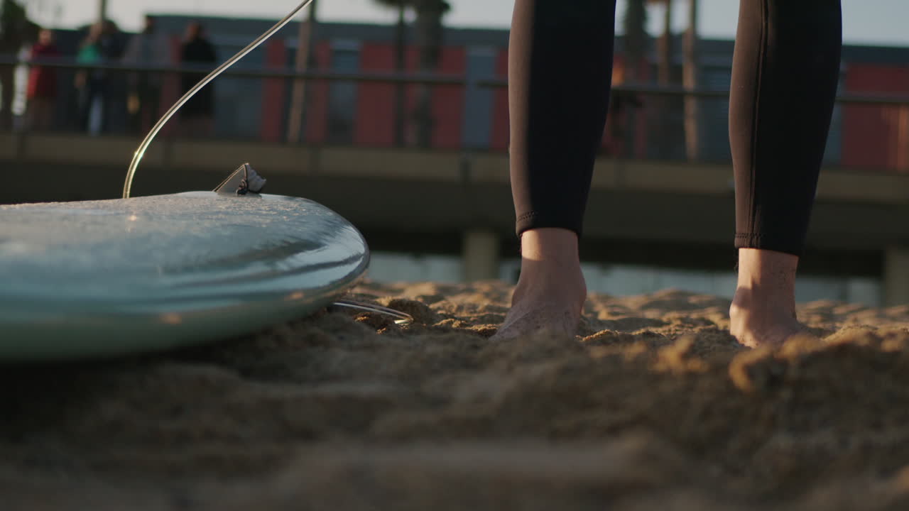 Surfer man walking to the beach at sunset preparing for surfing training and search for waves in Barcelona, spain, water, ocean exercise in sea with board, athletic male holiday or travel in vacation