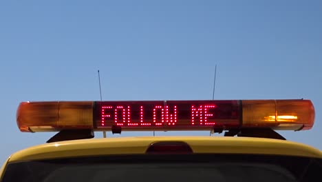 Airport-marshaller-car-displaying-a-bright-sign-of-FOLLOW-ME-with-space-left-for-text-or-logo