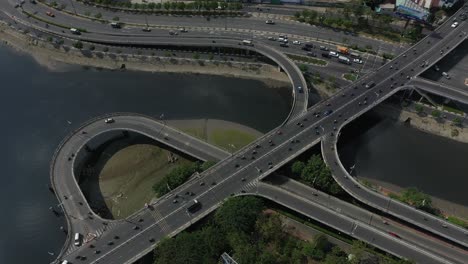 aerial shot above complex road system connecting bridges on and off ramps and loops over canal and river in ho chi minh city, vietnam on a sunny day