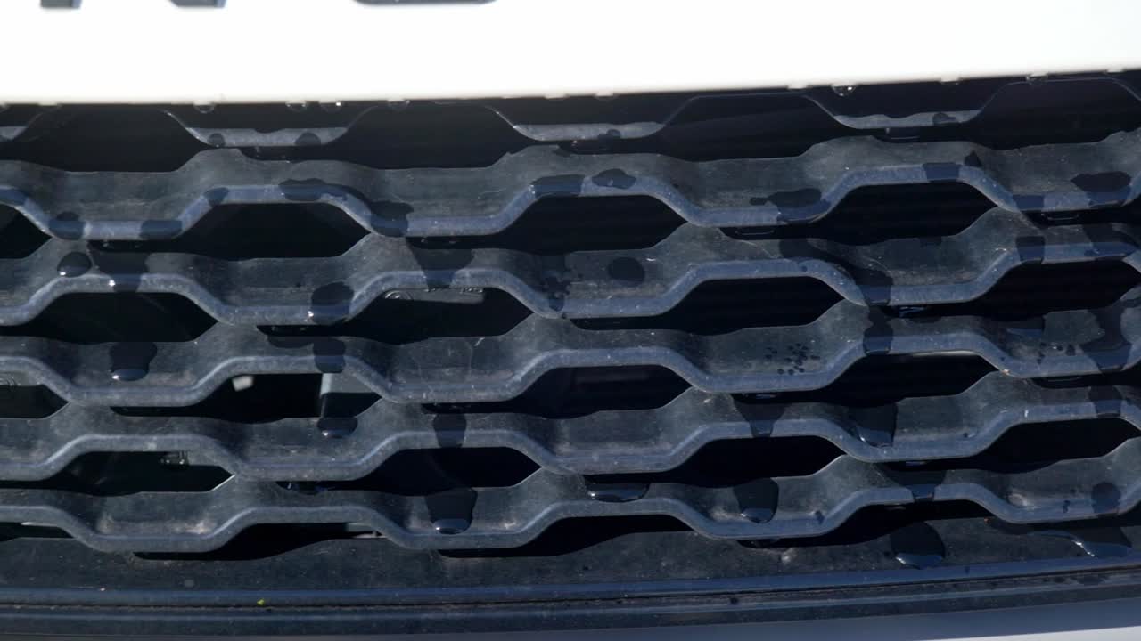 Dusty dirty black SUV grill left to right close up