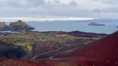 colorful volcanic landscape on heimaey island with ocean and distant islands in background