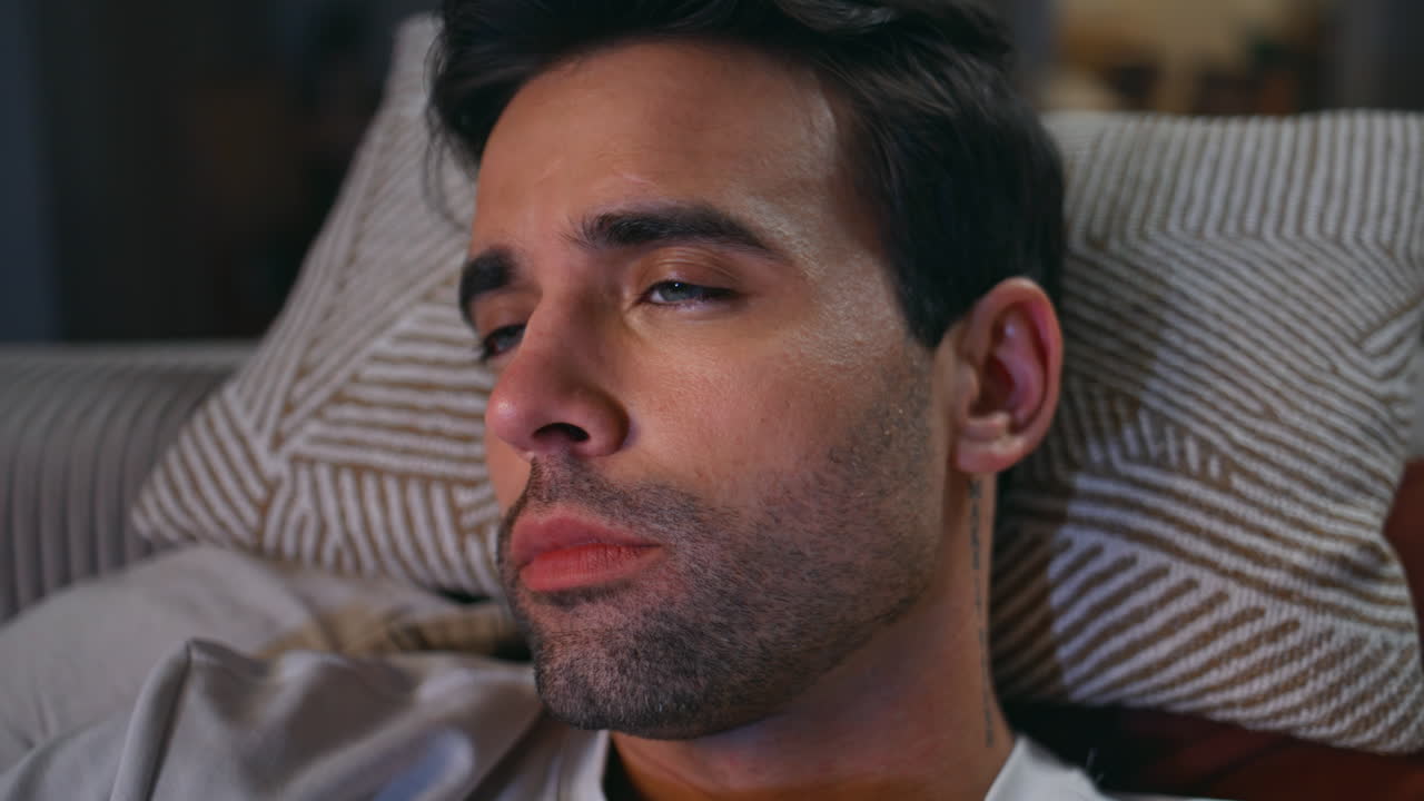 Closeup man sleeping sofa pillow in serene home ambiance. Portrait man napping