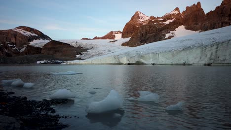 Ruhige-Morgenszene-Am-Gletschersee-Neben-Dem-Claridenfirn-Gletscher-In-Uri,-Schweiz,-Mit-Dem-Alpenglühen-Der-Alpengipfel-Im-Spiegel-Und-Eisbergen-Am-Ufer