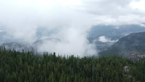 aerial footage looking through clouds above the mountains