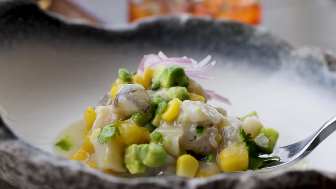 primer plano de camarón vibrante y ceviche de vieiras con aguacate y maíz en un cuenco rústico, mostrando ingredientes frescos y arte culinario