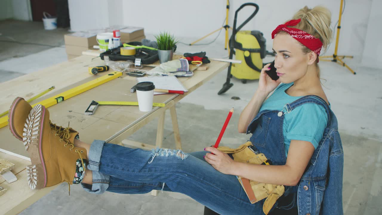 Carpintera en su puesto de trabajo hablando por smartphone