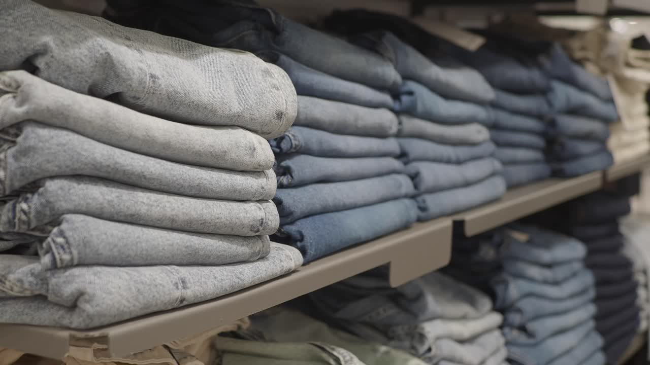Stacks of denim jeans on a shelf