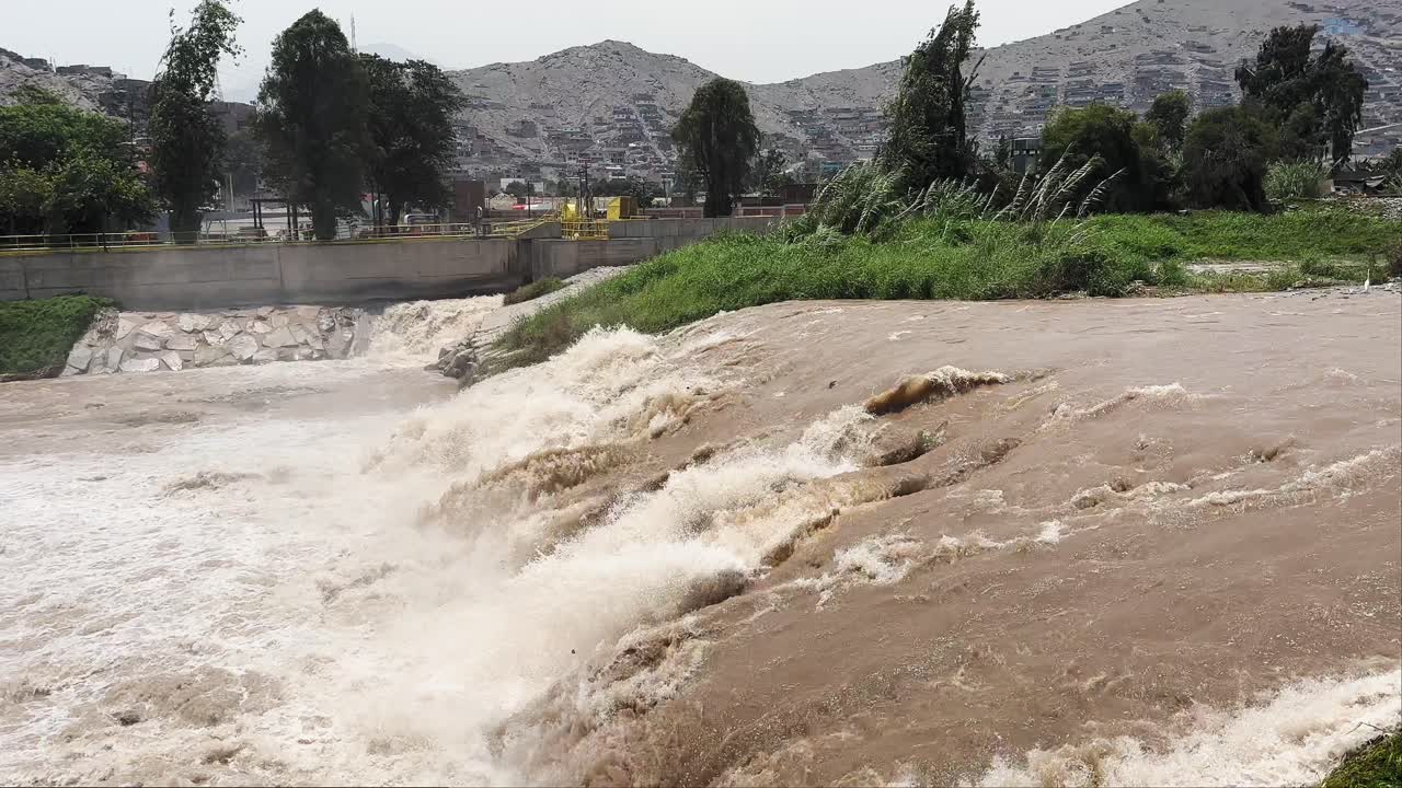 Polluted Brown Muddy River "Rio Rimac" flows in Lima, Perú 2023