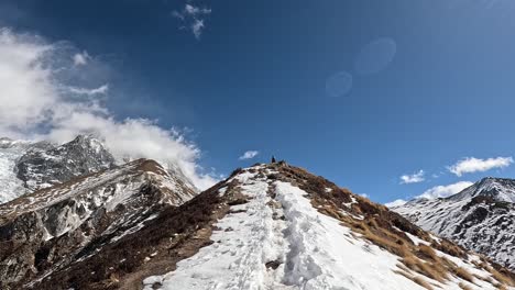 Una-Caminata-Aventurera-Por-Los-Senderos-Cubiertos-De-Nieve-Que-Conducen-A-La-Cima-De-Kyanjin-Ri,-Con-El-Impresionante-Telón-De-Fondo-Del-Macizo-Montañoso-De-Langtang-Lirung-Y-Los-Cielos-Azules-Profundos-En-Nepa