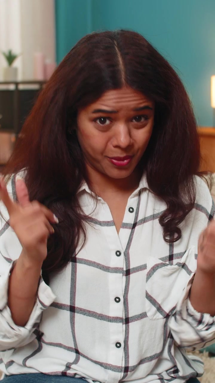 Indian woman gestures seriously looking at camera frustration disbelief angry expression indoor mood