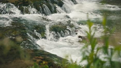 Vista-Cercana-Del-Agua-Que-Fluye-Rápidamente-Sobre-Rocas-Cubiertas-De-Musgo-En-El-Río-Slunjčica-En-Rastoke,-Croacia