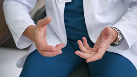 Doctor using hand sign while talking. Cropped view of doctor gesturing while talking in office