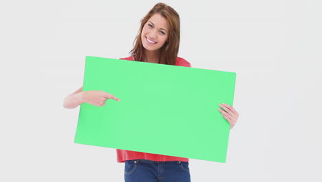 mujer sosteniendo y señalando un cartel en blanco