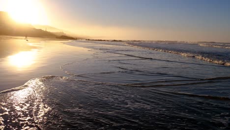 Sonnenstrahlen-Am-Frühen-Morgen,-Die-Bei-Sonnenaufgang-Vom-Nassen-Sand-Am-Strand-Reflektiert-Werden,-Wildnisstrand,-Südafrika