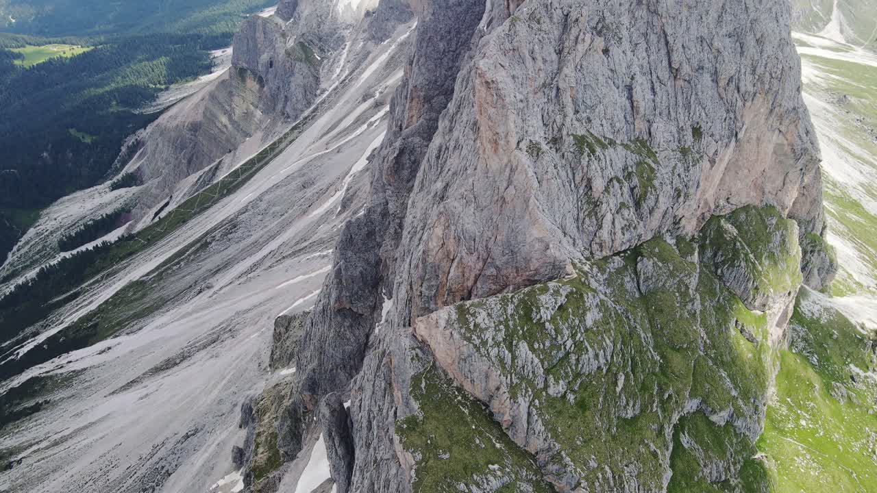 Smooth cinematic drone tilt reveals steep alpine rock faces Seceda Italy