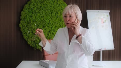 senior businesswoman on phone in modern office
