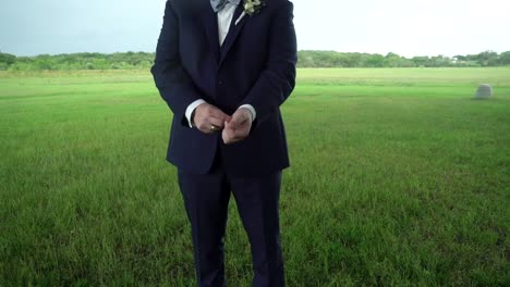 a groom fixes his cuffs