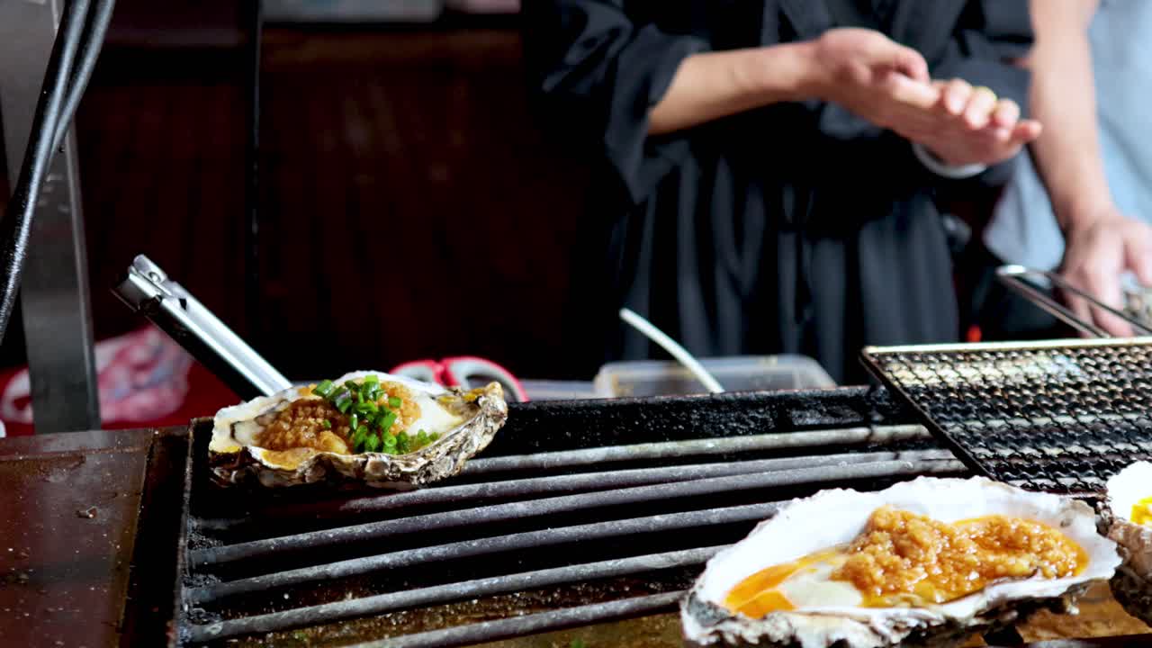 Oysters being grilled and prepared with toppings