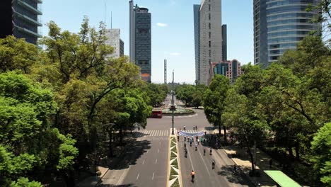 Rückwärts-Drohnenaufnahme-Von-Radfahrern,-Die-Am-Sonntag-Auf-Der-Reforma-Avenue-In-Mexiko-Stadt-Trainieren