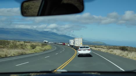siguiendo una serpiente de tráfico en la carretera de la silla isla de hawai en un día soleado viajando a kona