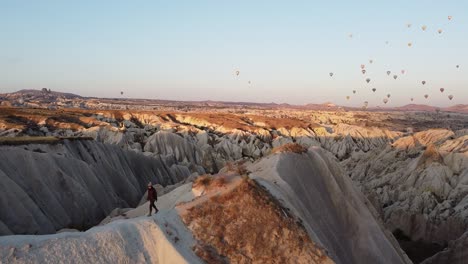 Young-girl-walking-at-sunrise-in-Cappadocia,-Turkey