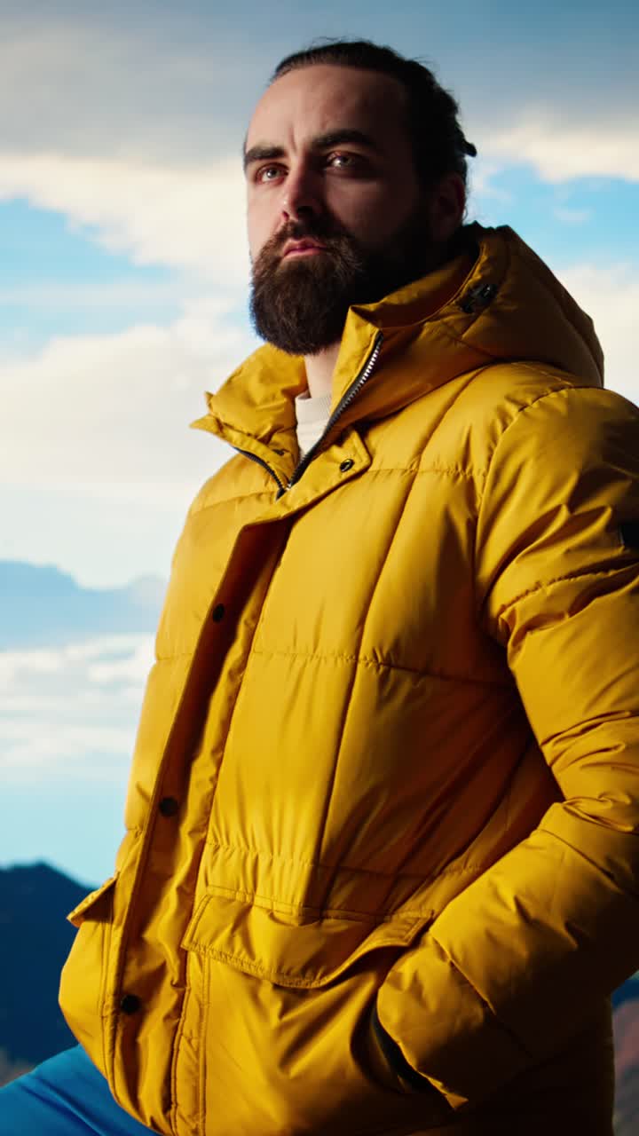 Man in Yellow Puffer Jacket Standing on Mountain Looking at View