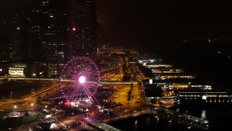 hong kong city skyline at night with ferris wheel