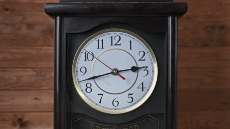 vintage wall clock with moving second hand on wooden background