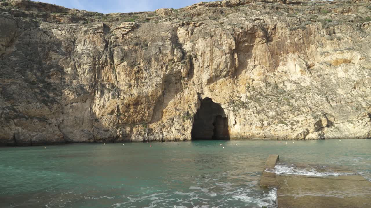 panorama de la zona de cuevas marinas interiores en malta con muelles de piedra que son lavados por agua de mar