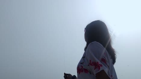 woman flying kite under bright sun, essence of serenity and outdoor joy, festivals themes.