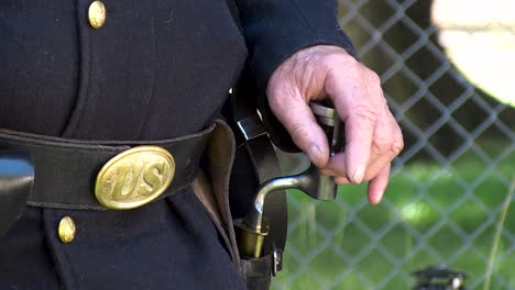close up of civil war uniform and soldier with hand on bayonet