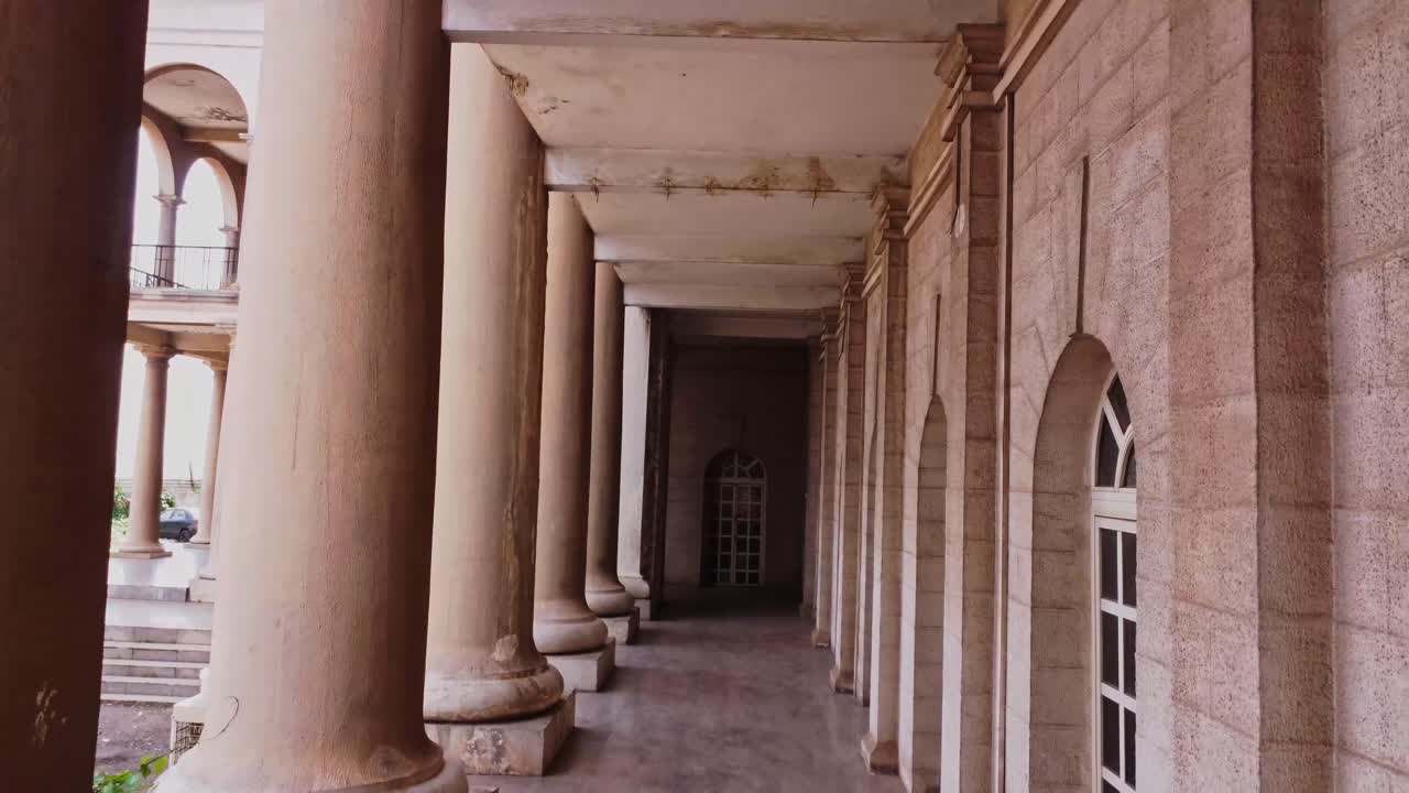 Drone flying past beautiful old columns of Mapo Hall in Ibadan, Nigeria