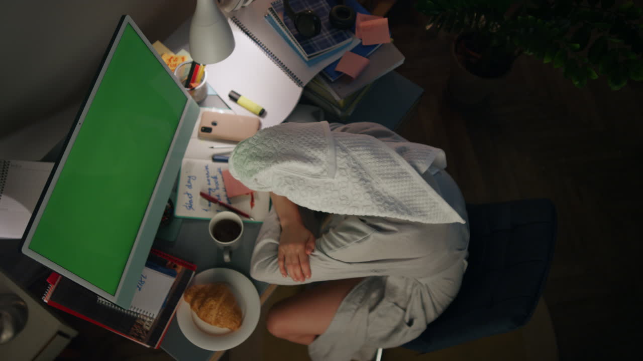 Donna stanca che si addormenta alla postazione di lavoro remota, vista dall'alto. Ragazza assonnata che fa un pisolino a casa.