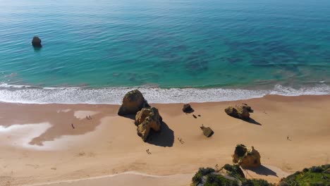 una playa vacía con arena dorada y un océano azul en algarve, portugal