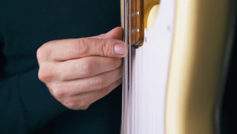 funky-artist-plays-solo-on-white-bass-guitar-with-finger