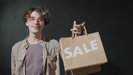 portrait of young handsome man with sale shopping bag