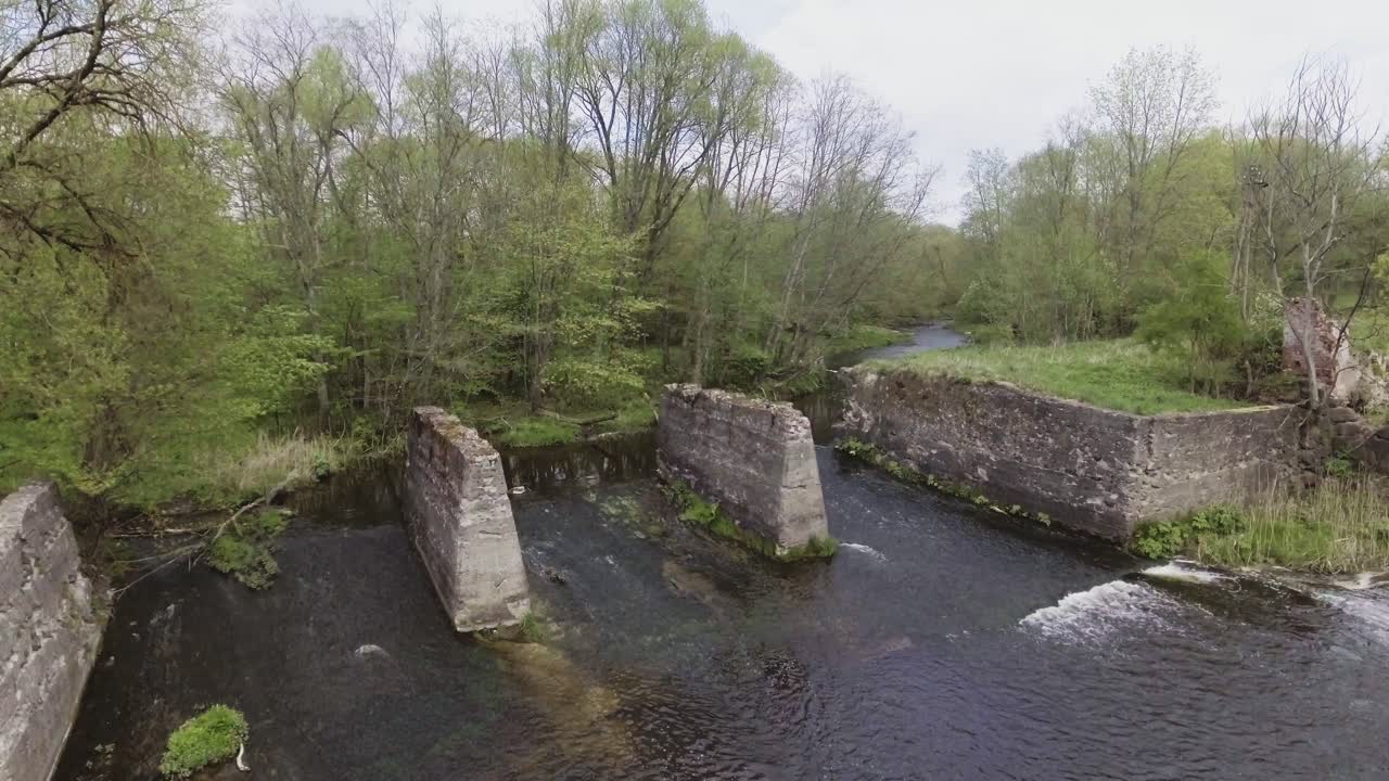 Remains of the watermill of fragments of Musninkai (Musninkeliai) manor homestead. 4K aerial dolly-out